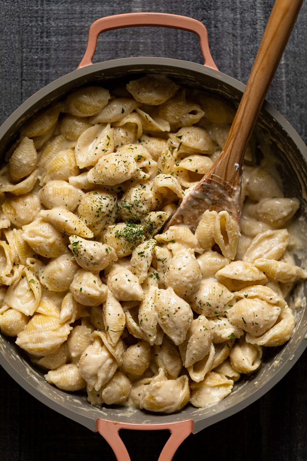 Wooden spoon stirring a pan of Vegan Mac and Cheese