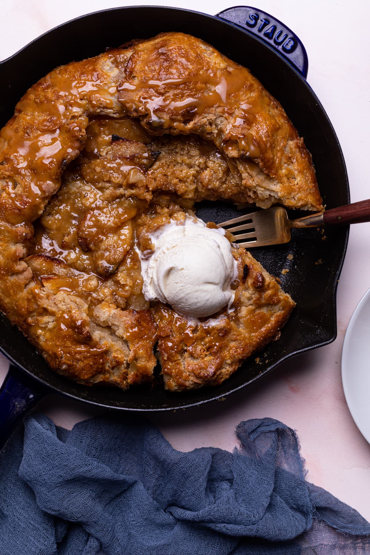 Salted Caramel Apple Skillet Galette on a table with a blue cloth napkin.