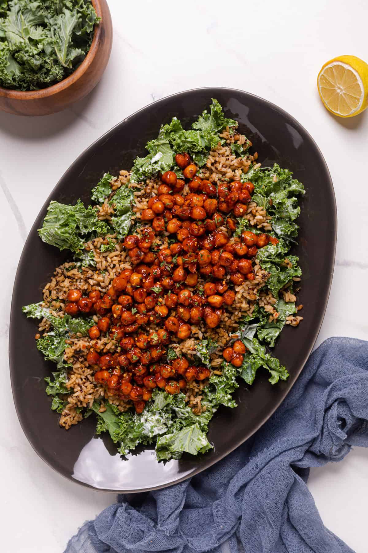 Healthy Loaded Kale Salad with Spicy Chickpeas on a black serving platter