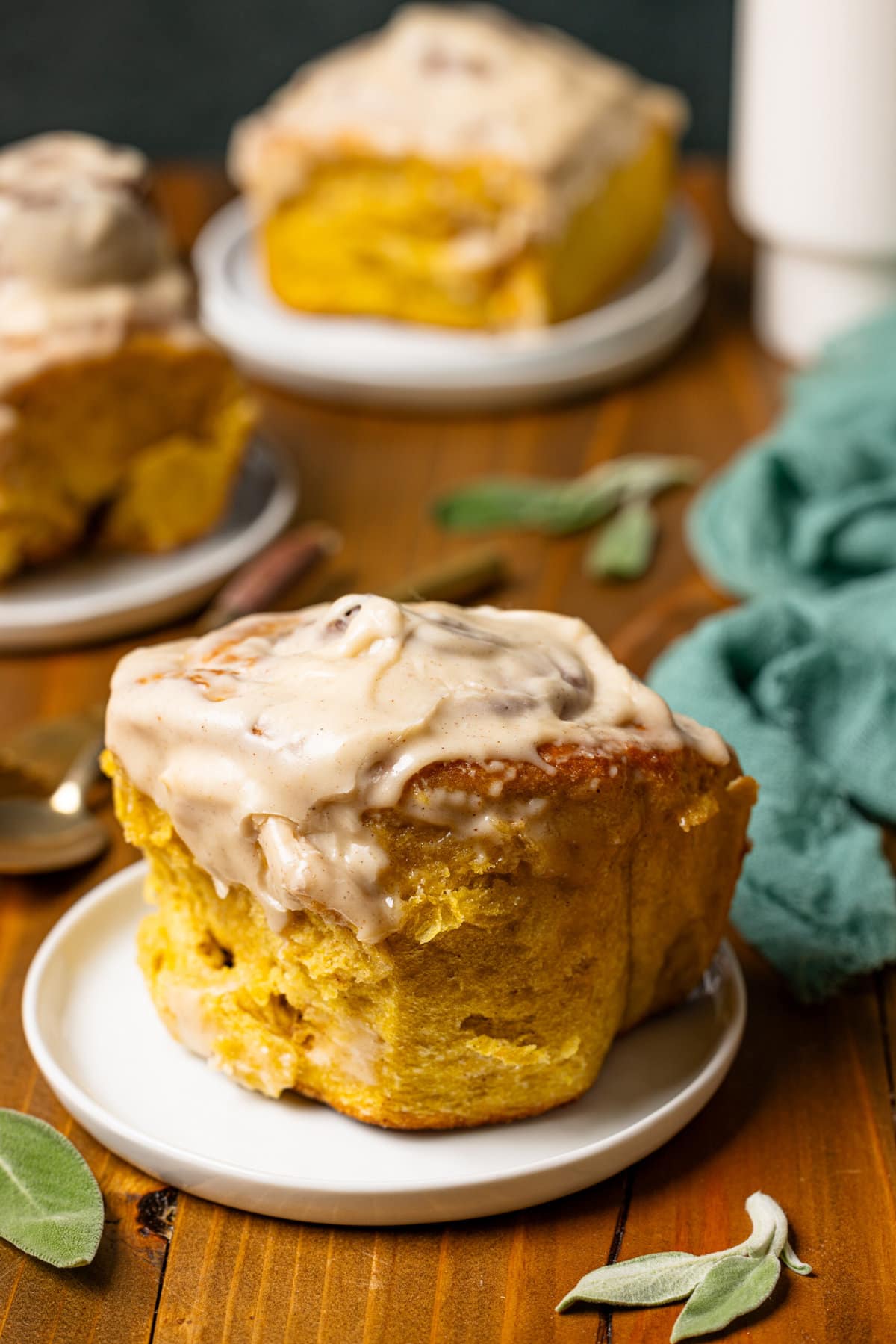 Up close shots of cinnamon rolls on white plates.