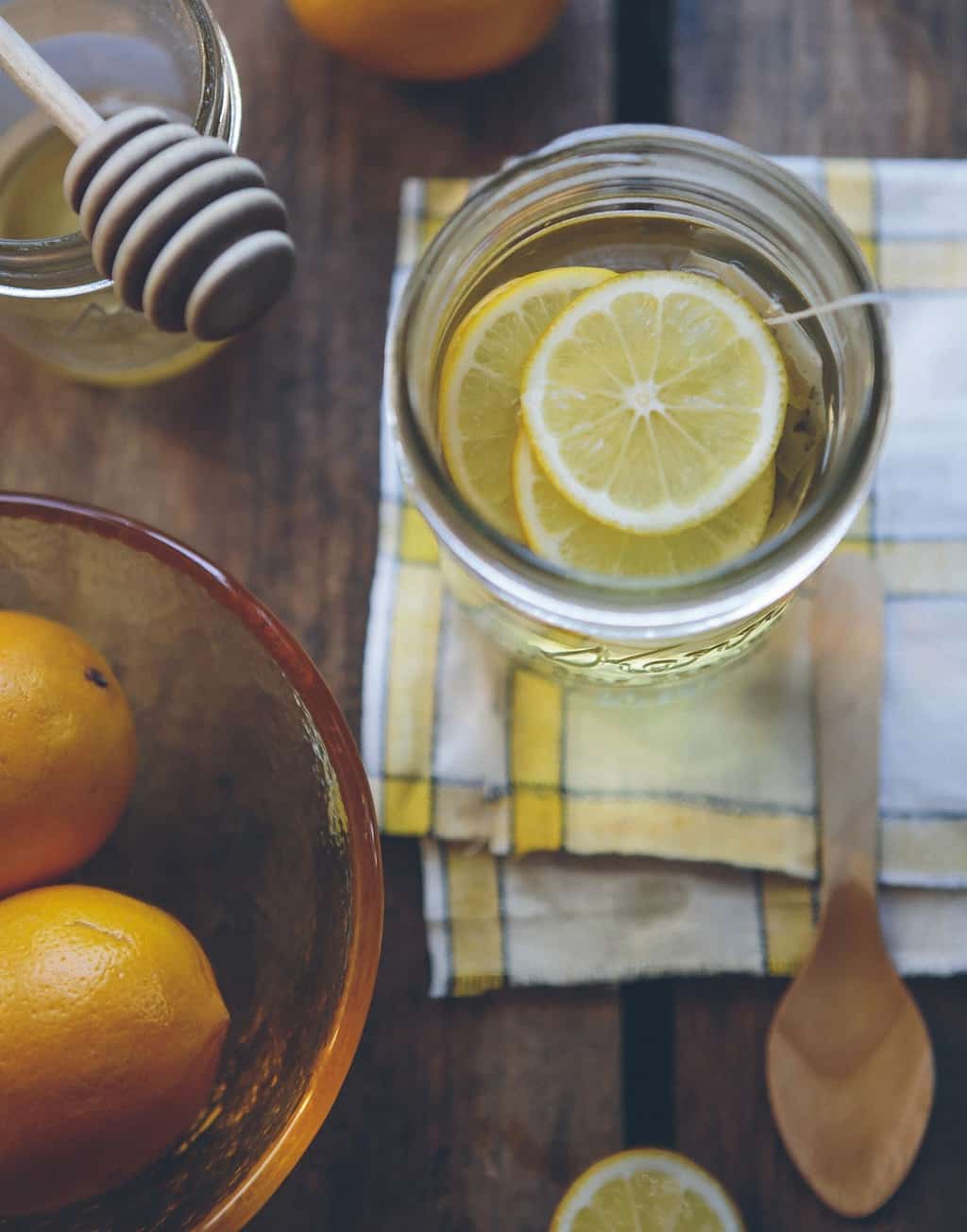 Tea bag in a jar with water and lemon slices.