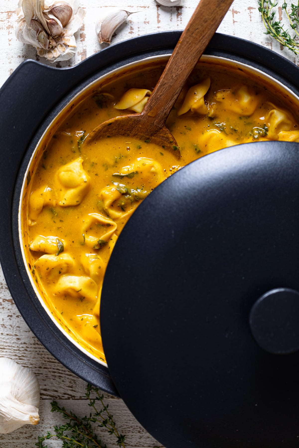 Pot of Creamy Cajun Pumpkin Tortellini Soup with the lid half on