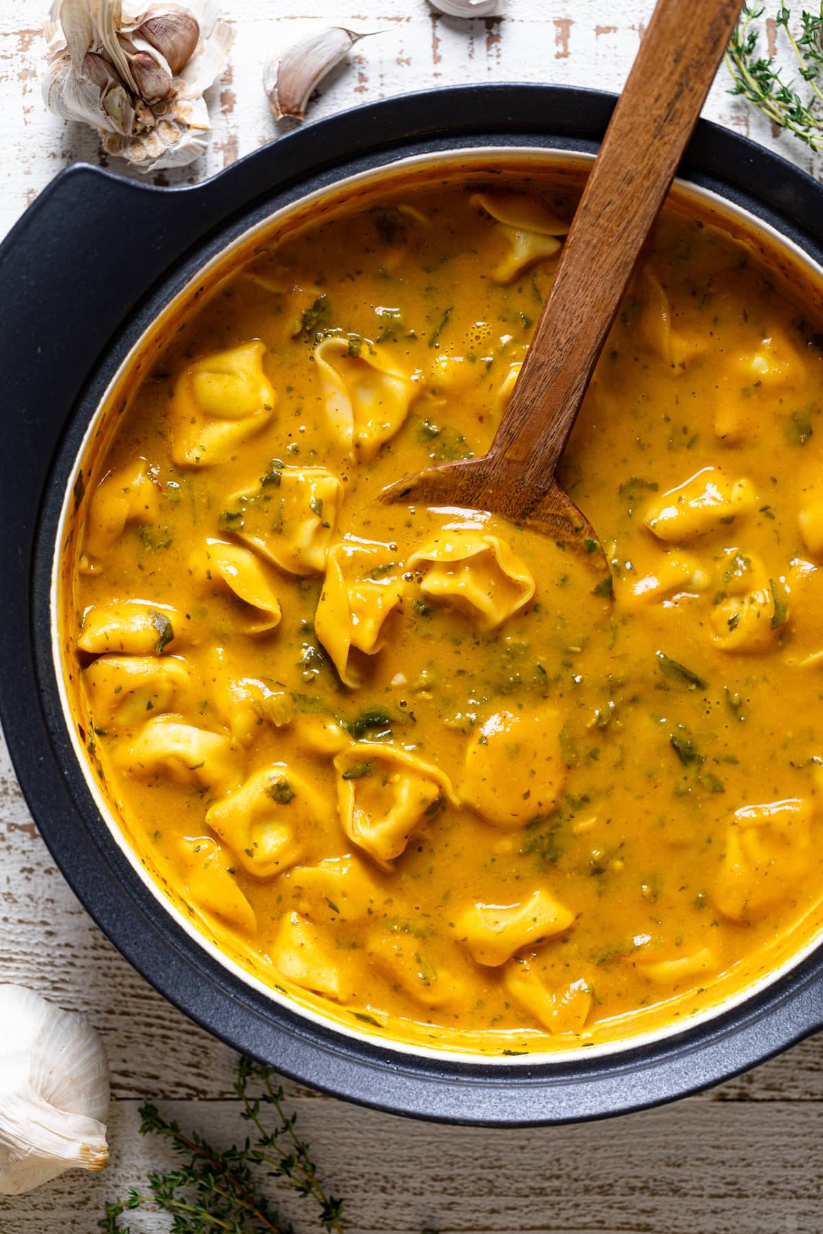 Wooden spoon in a pot of Creamy Cajun Pumpkin Tortellini Soup