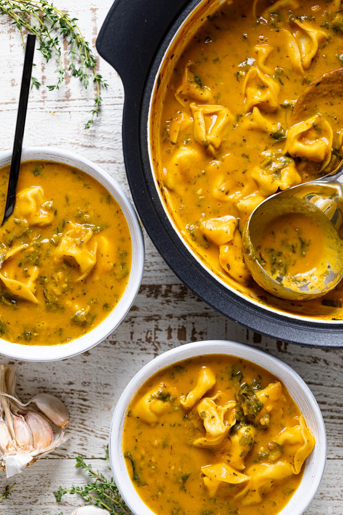 Pot and two bowls of Creamy Cajun Pumpkin Tortellini Soup