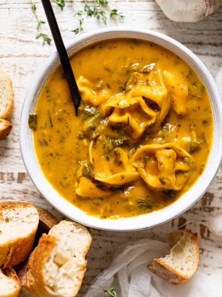 Bowl of Creamy Cajun Pumpkin Tortellini Soup and a bowl of bread