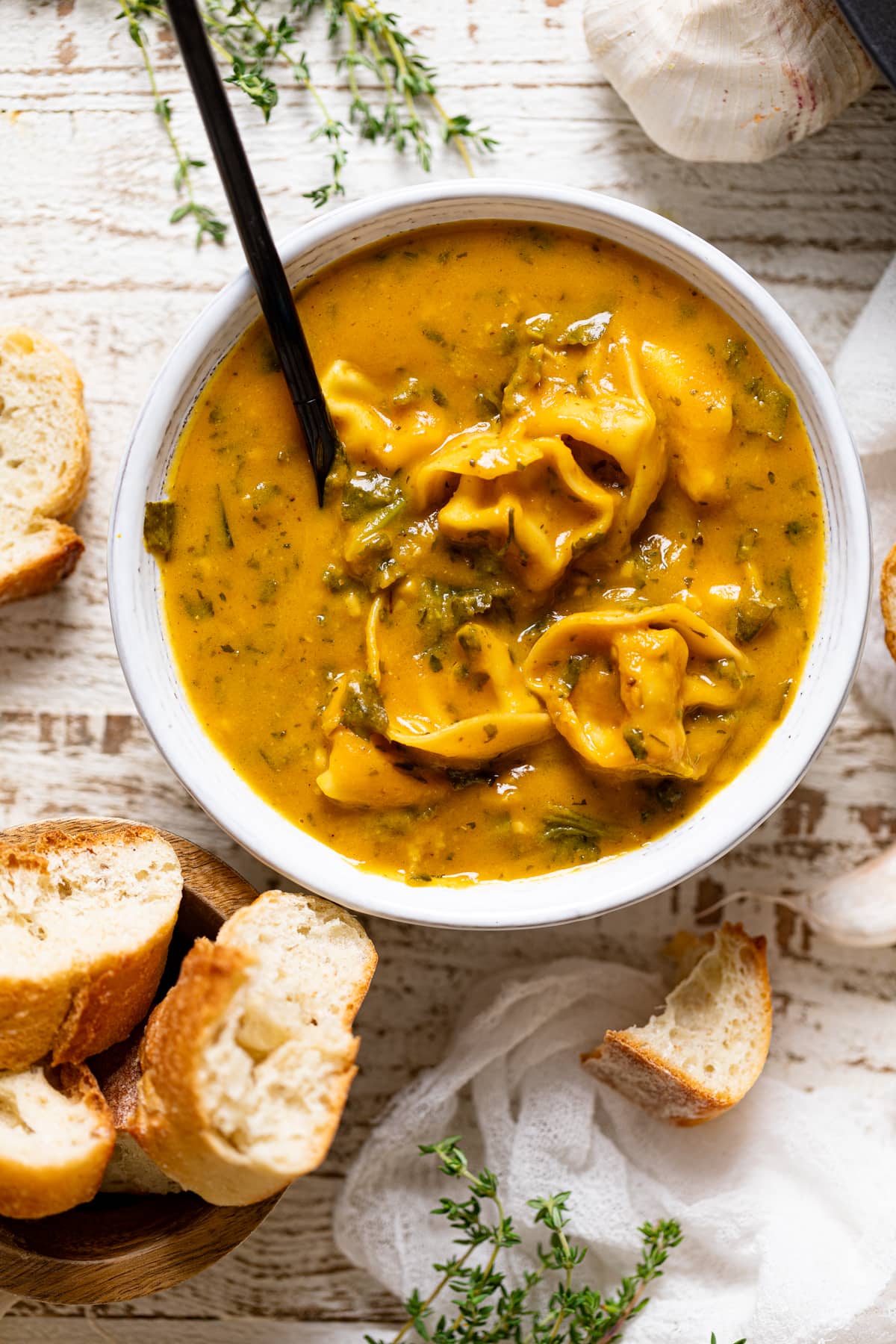 Bowl of Creamy Cajun Pumpkin Tortellini Soup and a bowl of bread