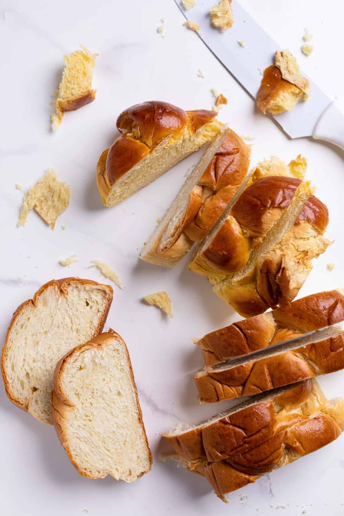 Overhead of slices of challah bread on a marble counter.