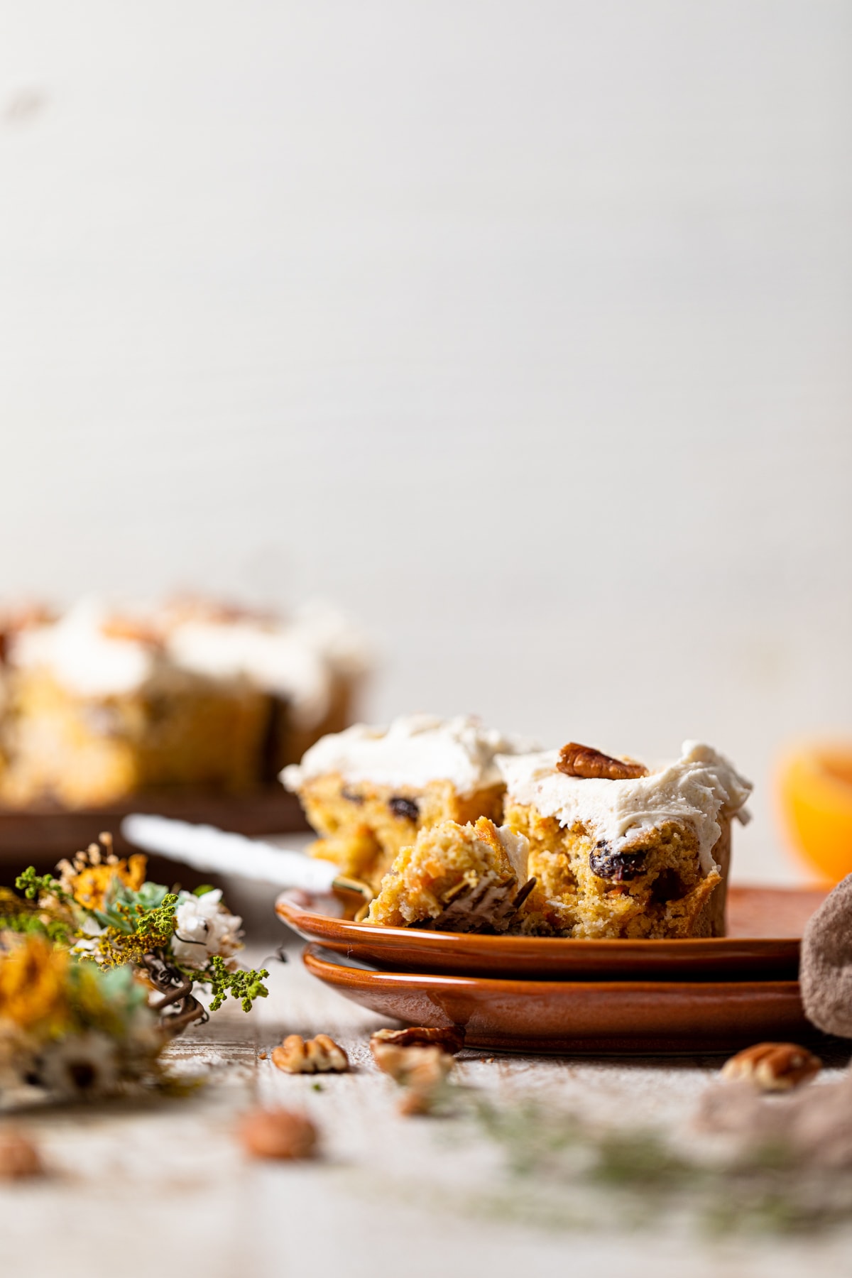 Piece of Vegan Carrot Cake with Orange-infused Frosting on two small, stacked plates