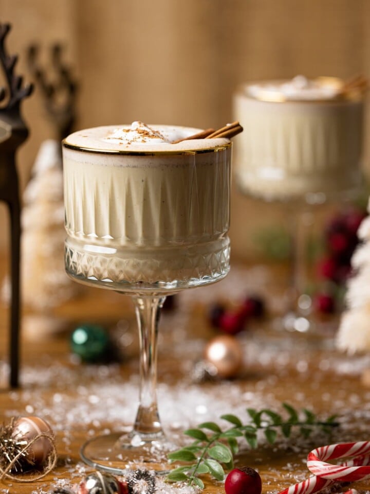 Two long-stemmed glasses of Creamy Homemade Vegan Eggnog.