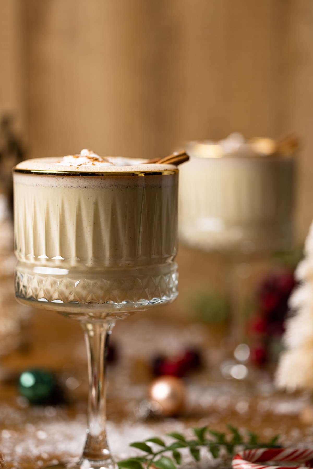 Creamy Homemade Vegan Eggnog in a long-stemmed, gold-rimmed glass.