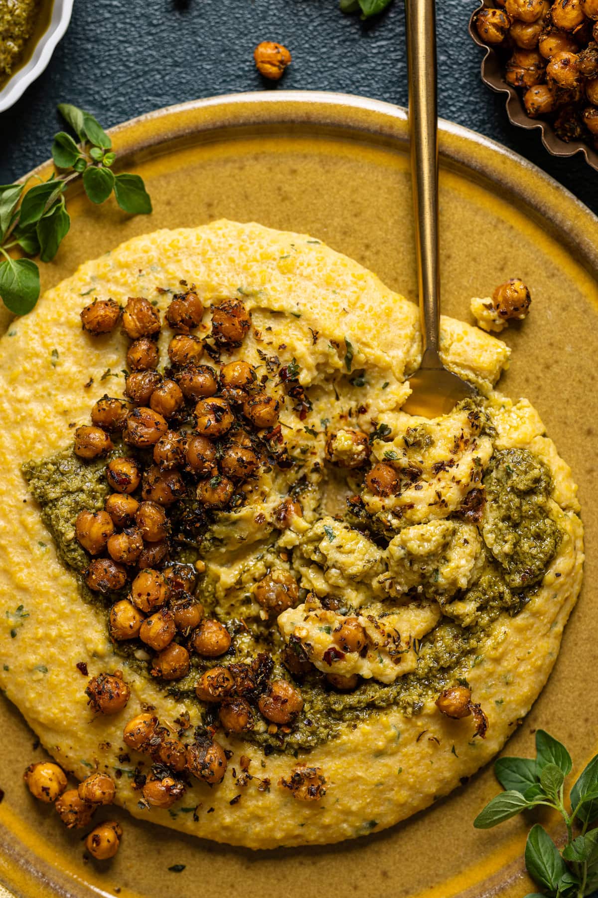 Closeup of Vegan Cheese Polenta with Pesto with Chickpeas and a spoon