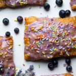 Homemade Blueberry Vegan Pop Tarts with blueberries on a white surface.