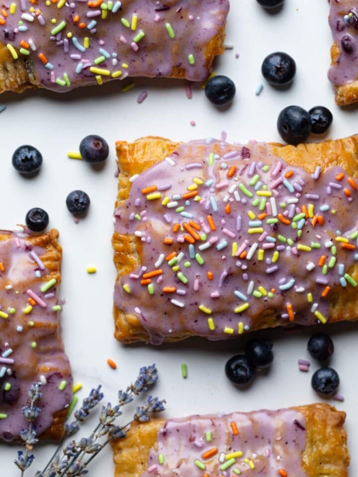 Homemade Blueberry Vegan Pop Tarts with blueberries on a white surface.