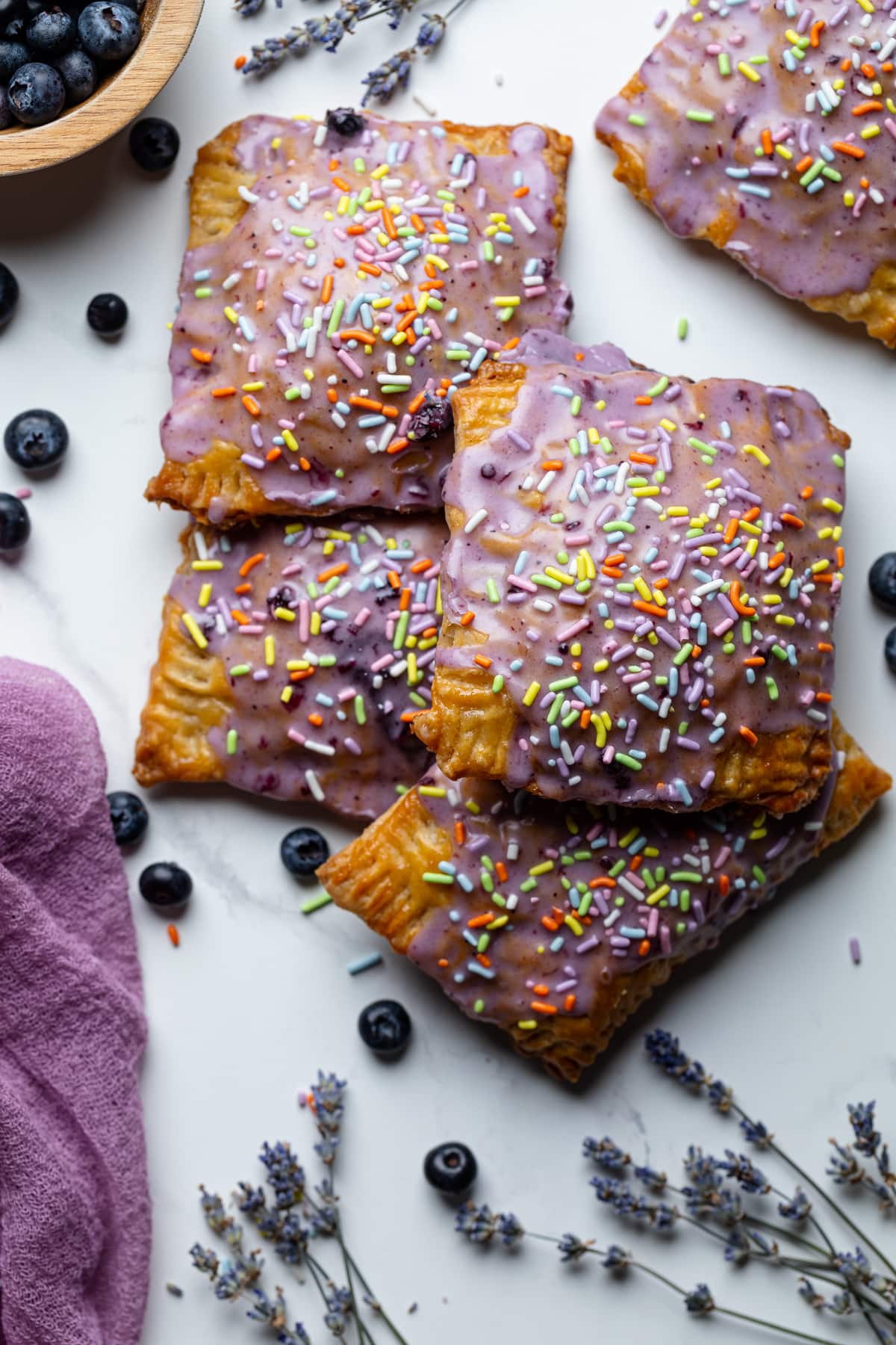 Homemade Blueberry Vegan Pop Tarts piled on a marble countertop.