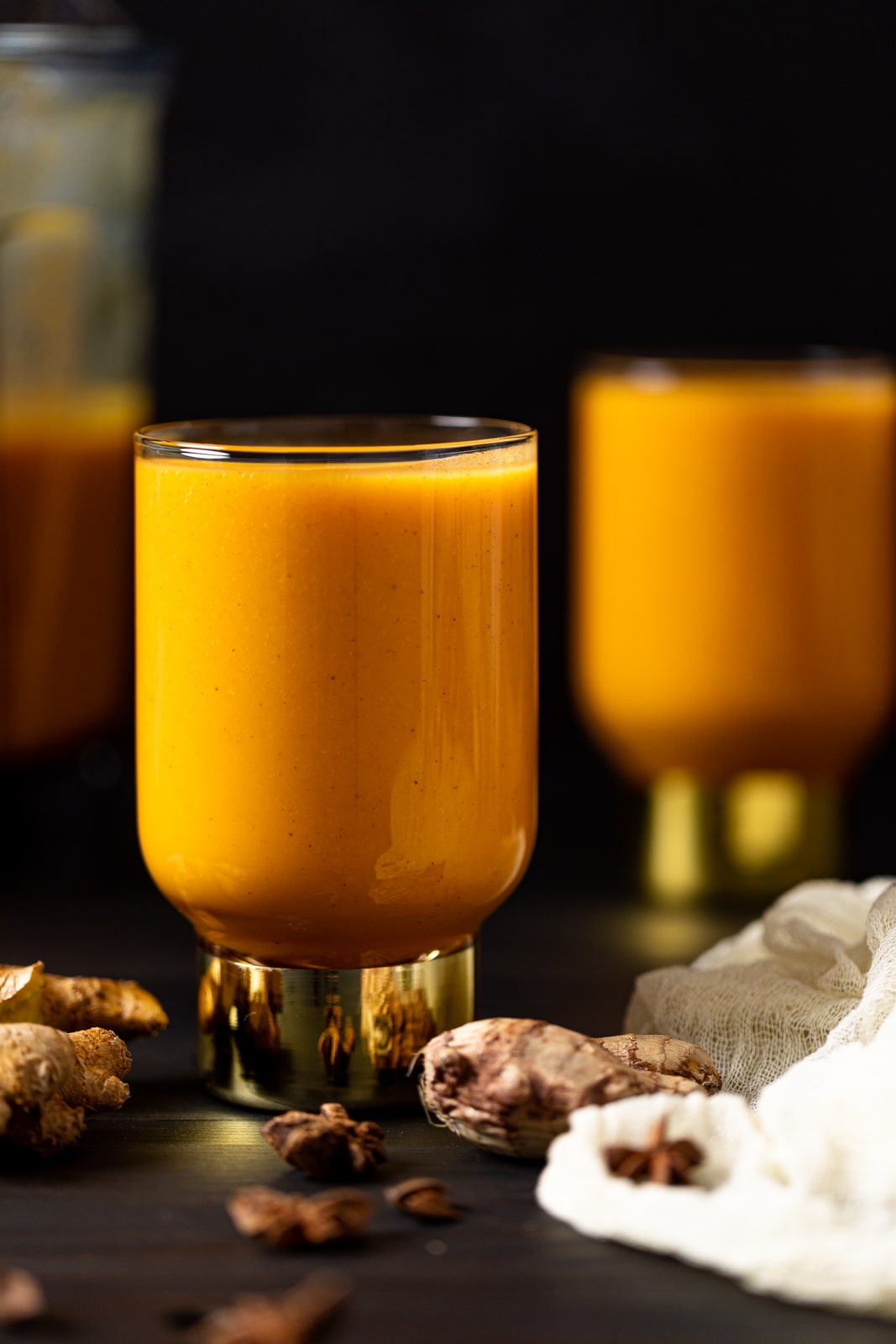 Vegan Jamaican Carrot Juice in a small glass with a golden base