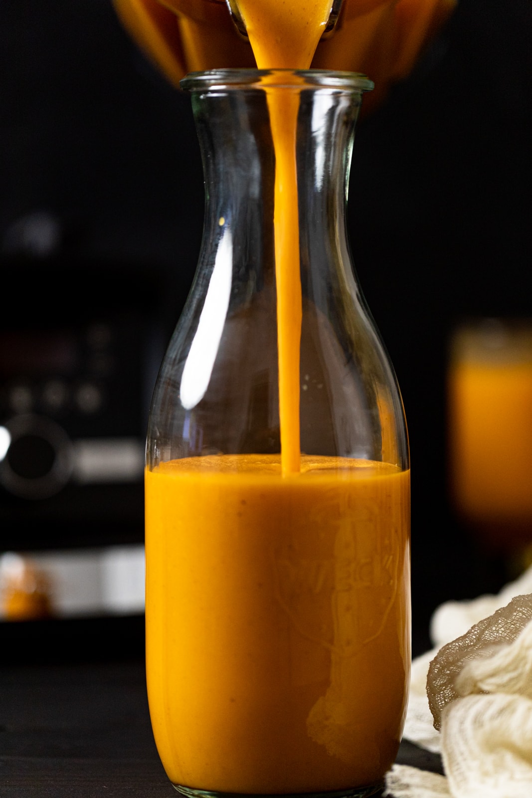 Vegan Jamaican Carrot Juice pouring into a glass carafe