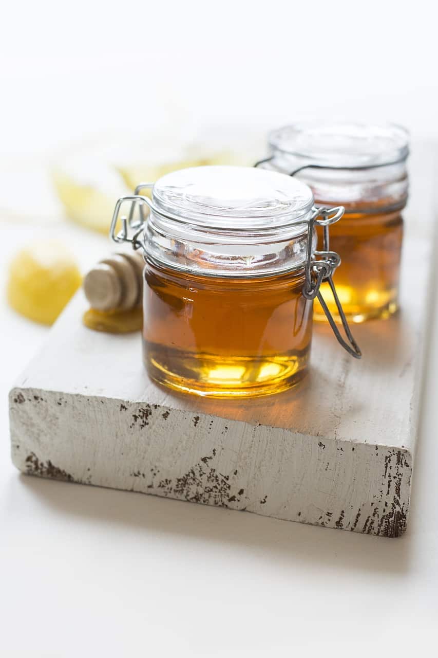 Jars of honey with a honey dipper.