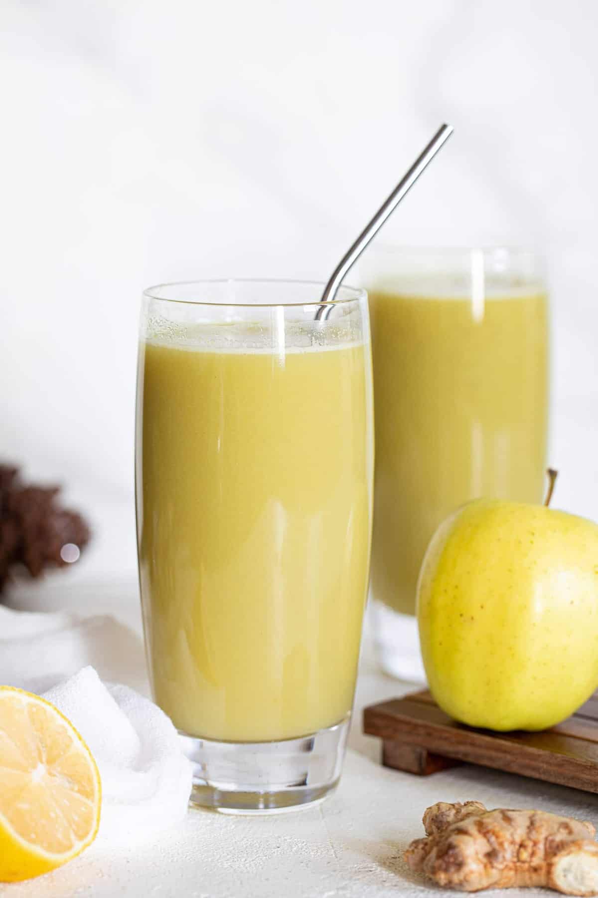 Metal straw in a tall glass of Cucumber Ginger Lemon Detox Juice.