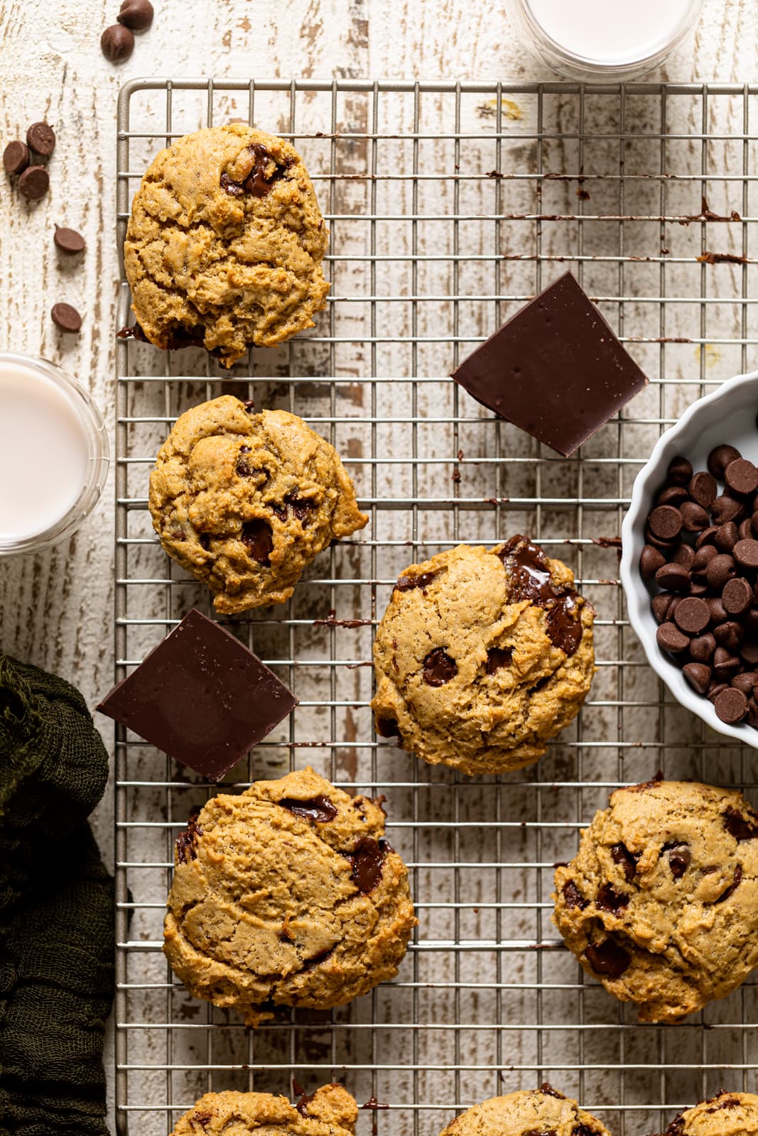 Vegan Chocolate Chip Cookies, chocolate chips, and chunks of chocolate on a wire rack