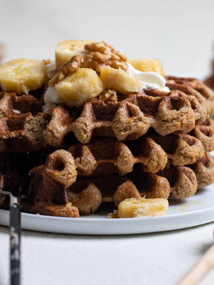 Flourless Vegan Banana Oats Waffles topped with bananas and nuts.