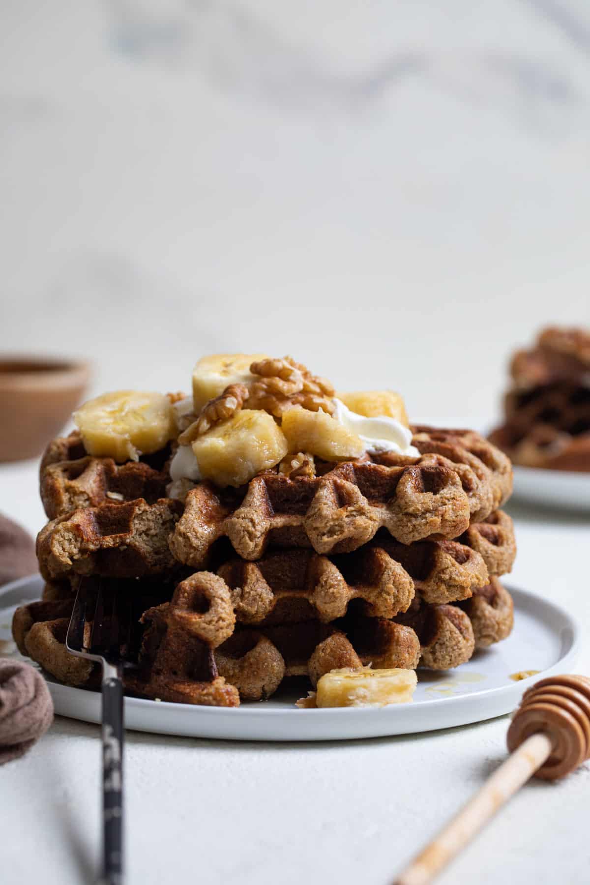 Flourless Vegan Banana Oats Waffles topped with bananas and nuts.