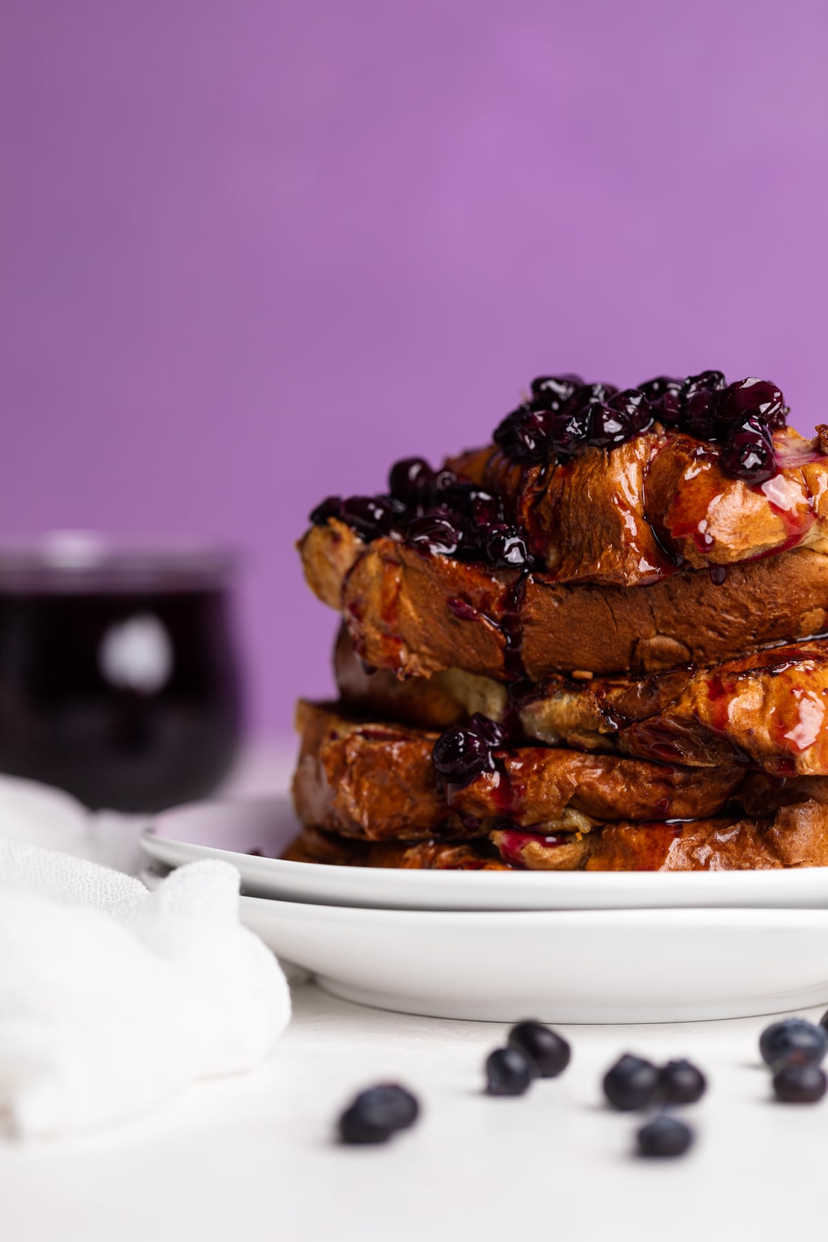 Dairy-Free Blueberry French Toast stacked on two white plates.