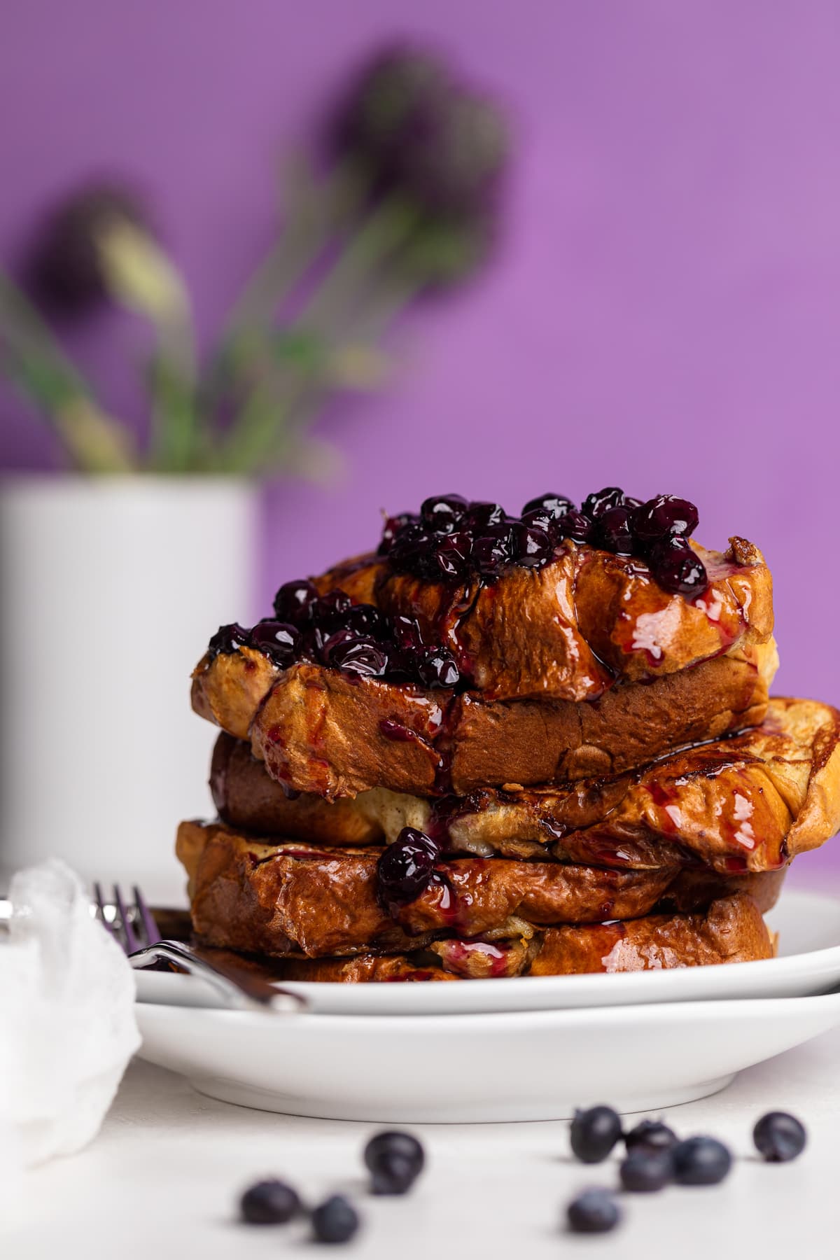 Dairy-Free Blueberry French Toast stacked on a plate with a fork.