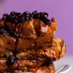 Blueberries and sauce running down the sides of Dairy-Free Blueberry French Toast.