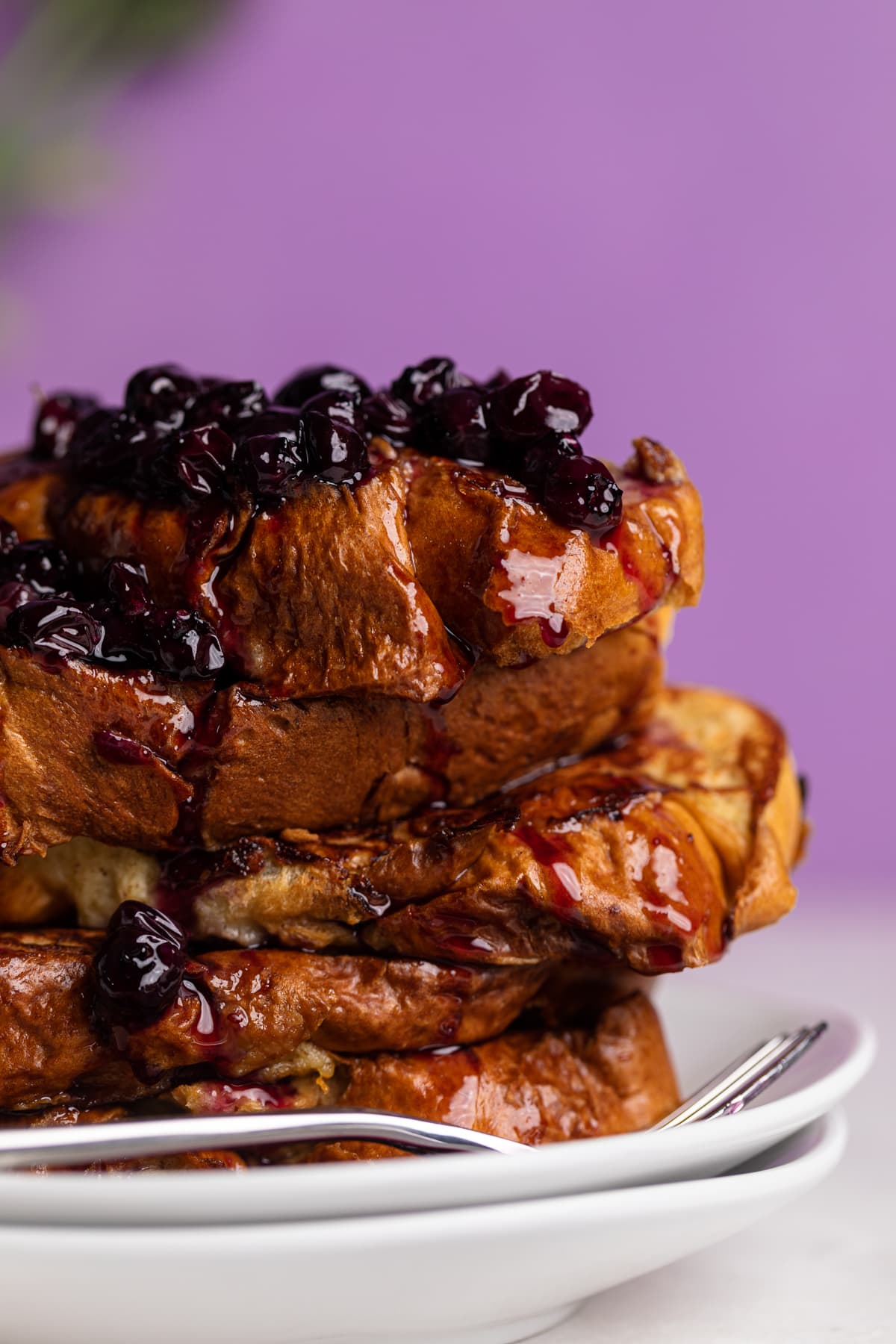 Blueberries and sauce running down the sides of Dairy-Free Blueberry French Toast.