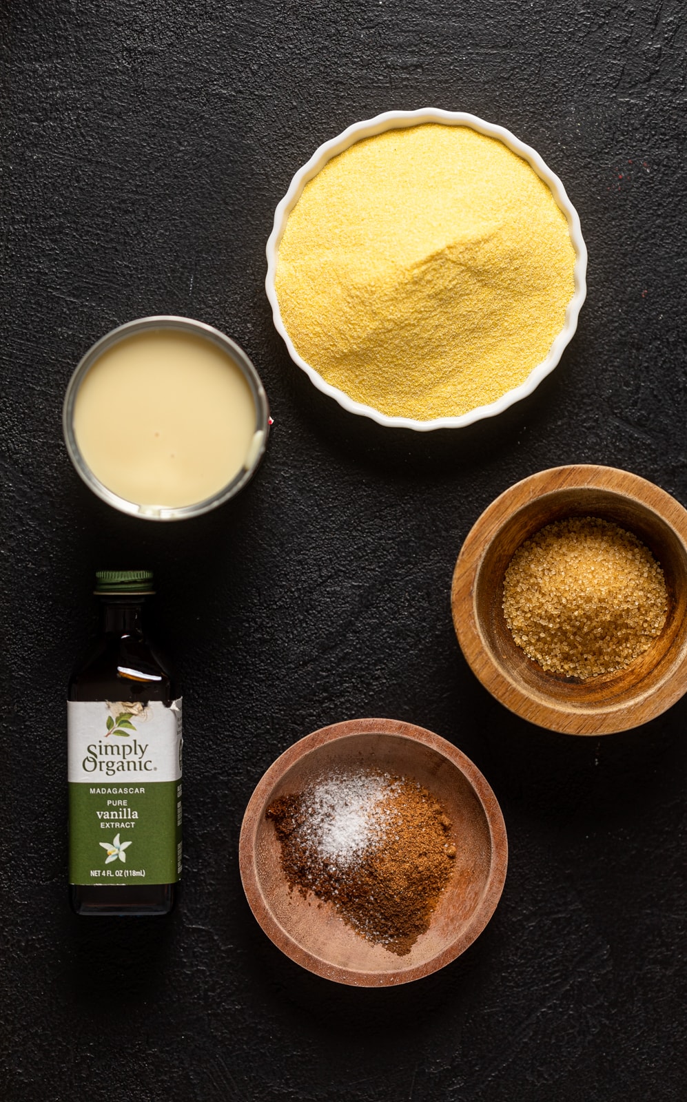 Ingredients for Creamy Jamaican Cornmeal Porridge including vanilla extract, cornmeal, and seasonings