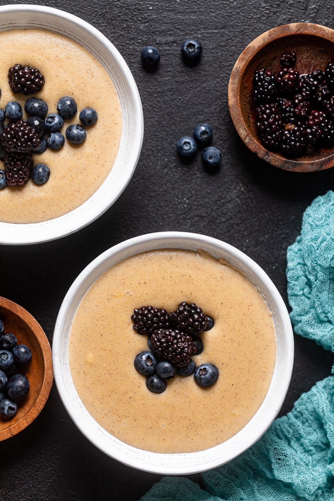 Overhead shot of two bowls of Creamy Jamaican Cornmeal Porridge