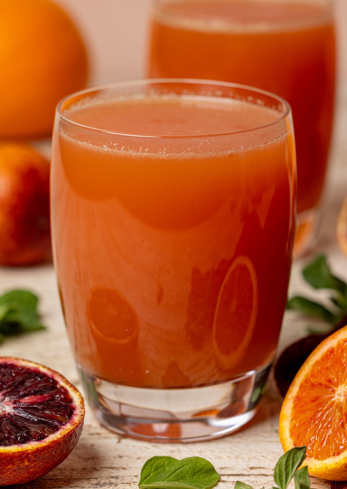 Up close shot of juice in two glasses with blood oranges.