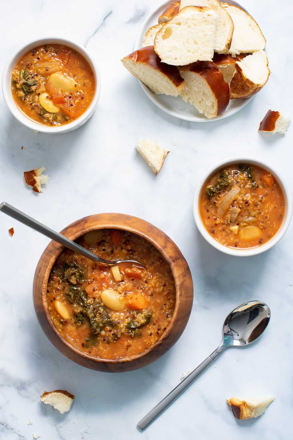 Bowls of Quinoa Veggie Soup on a marbled countertop.