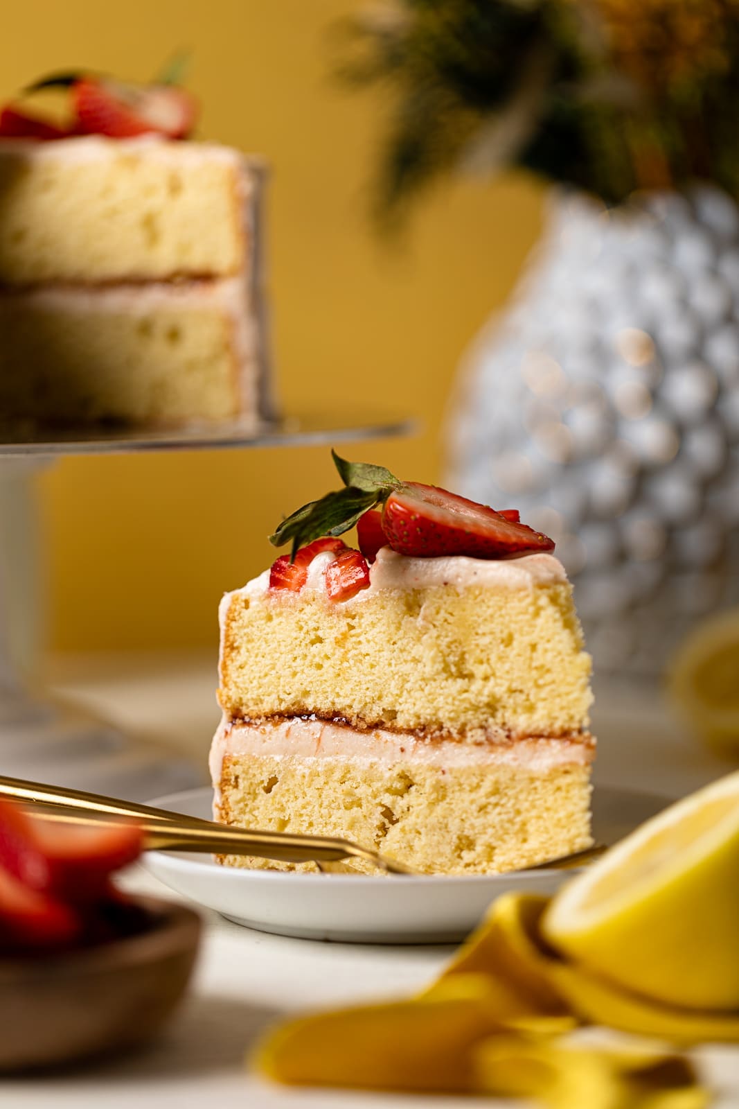 Slice of Lemon Strawberry Layer Cake and a fork on a small plate