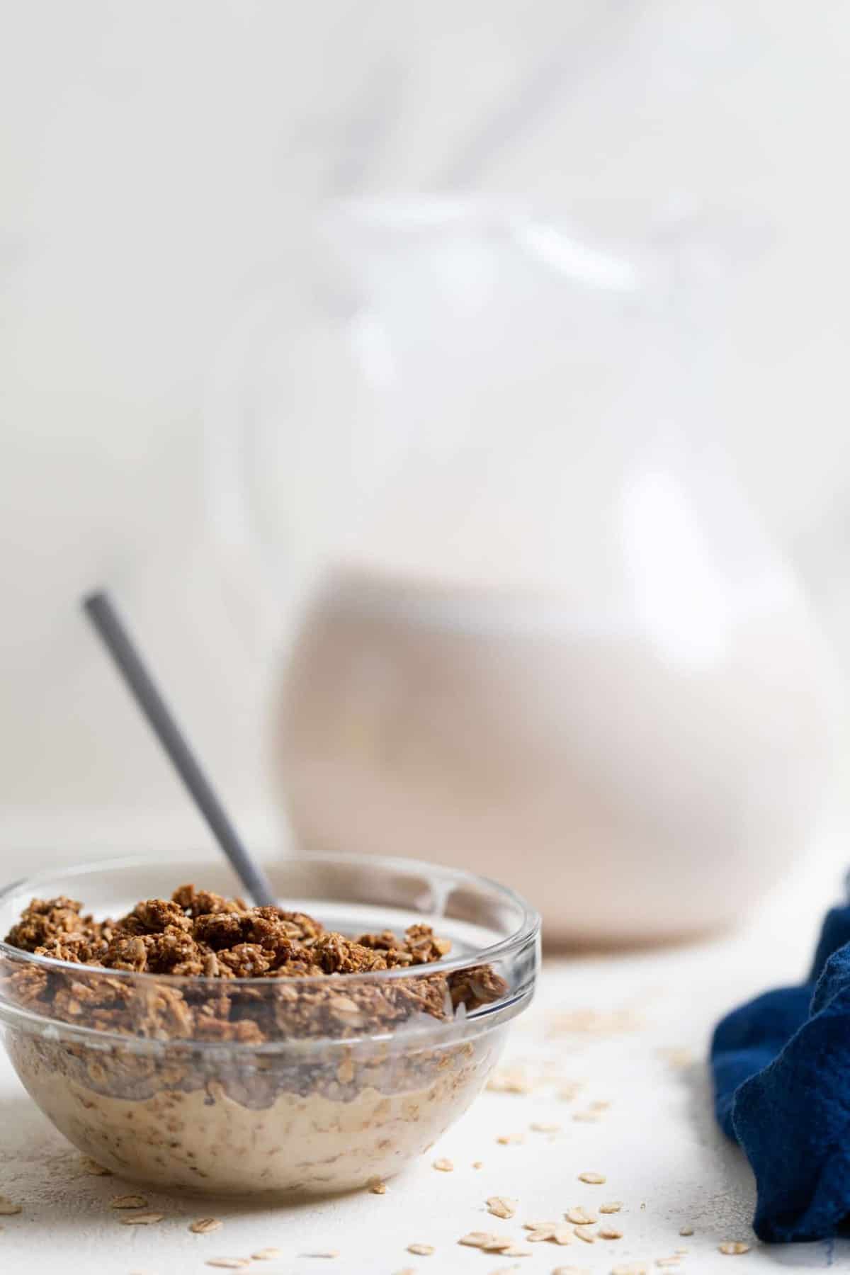 Spoon in a bowl of Creamy Homemade Oat Milk and granola.