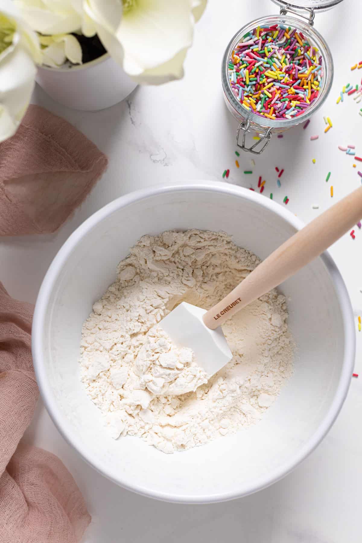 Spatula in a bowl of dry ingredients.