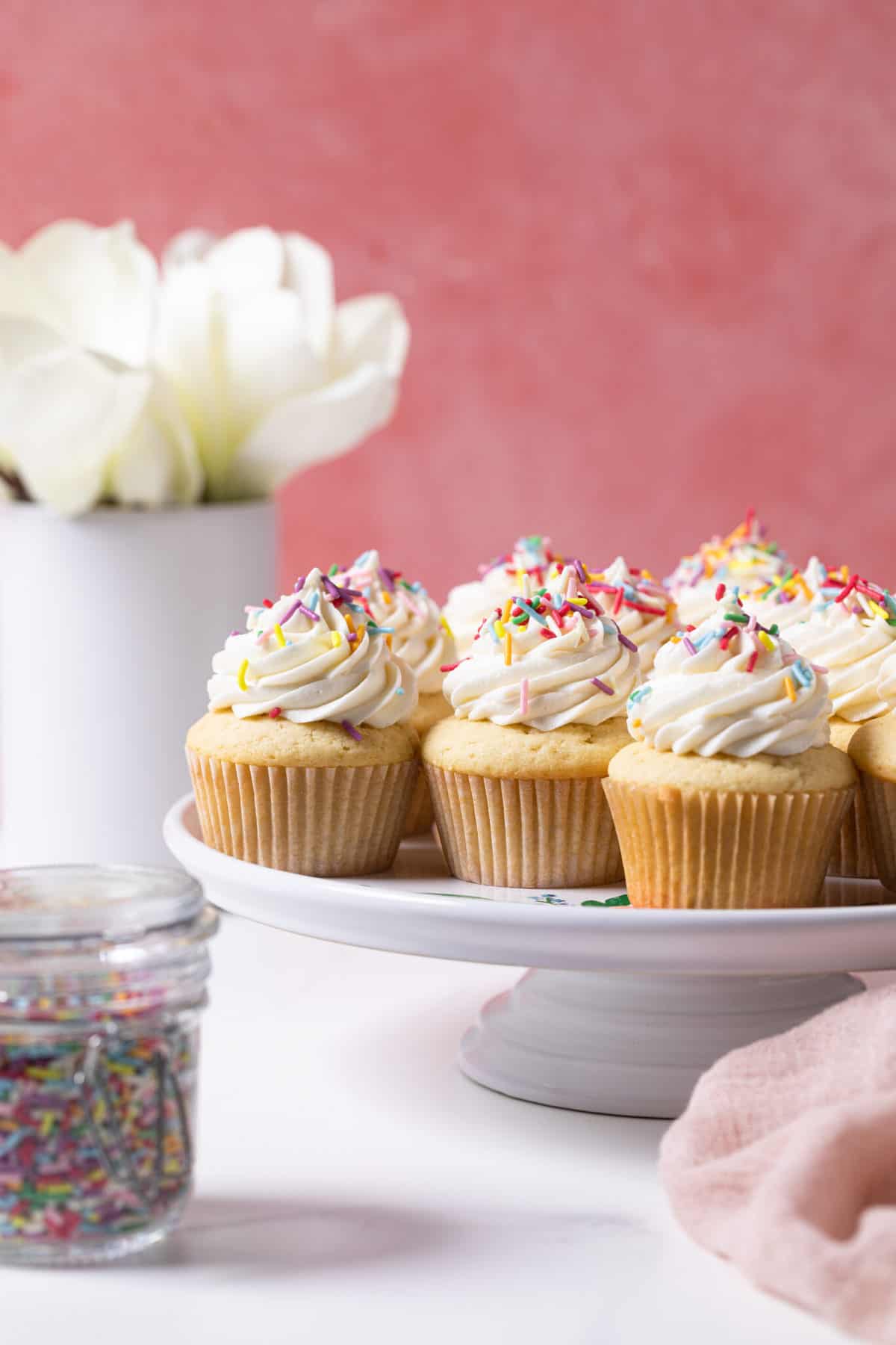 White, raised platter of Vanilla Cupcakes with Buttercream Frosting.