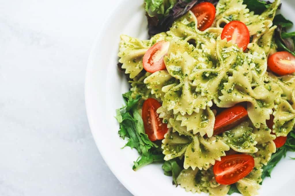 Plate of pasta topped with tomatoes.