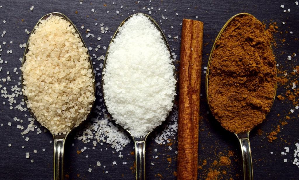 Spoons filled with different kinds of sugar.