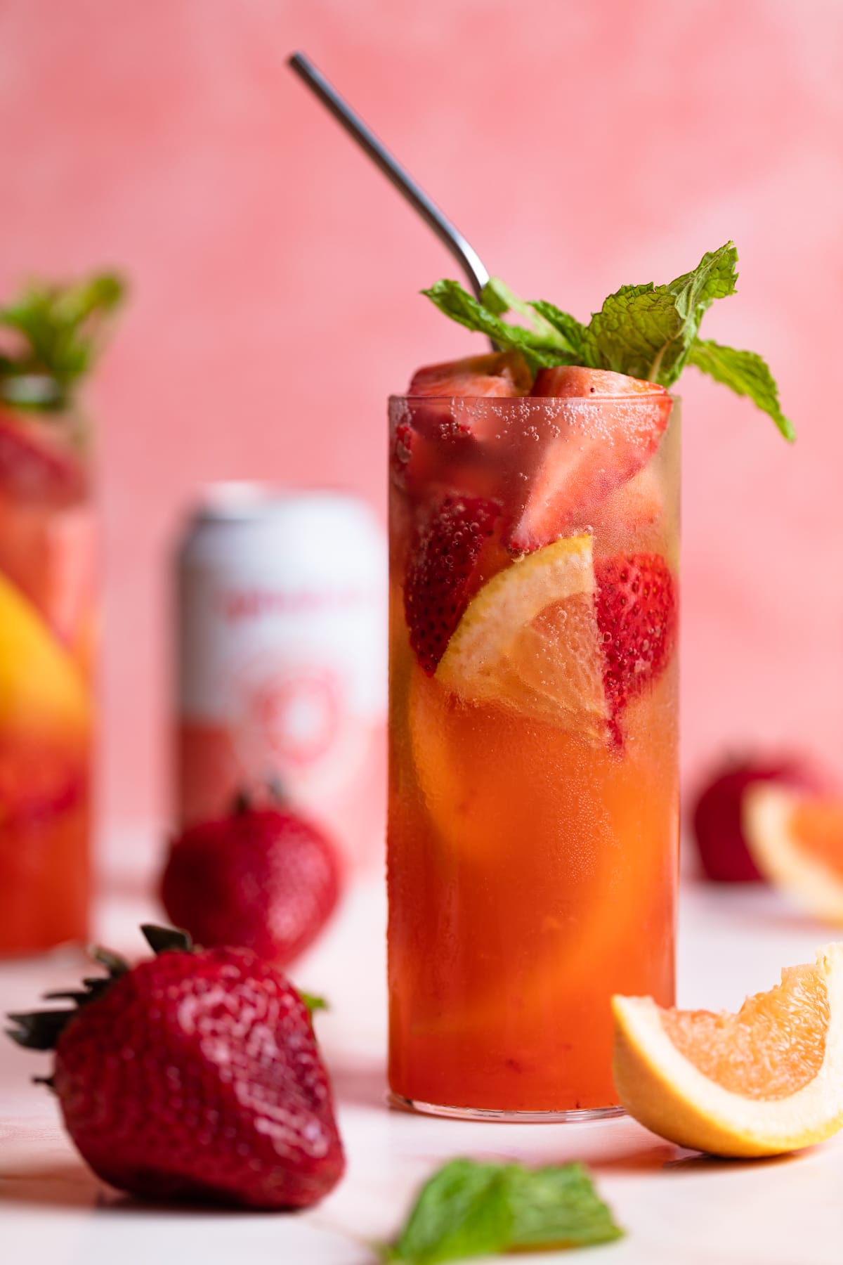 Strawberry Grapefruit Mint Spring Soda surrounded by strawberries and grapefruit pieces.