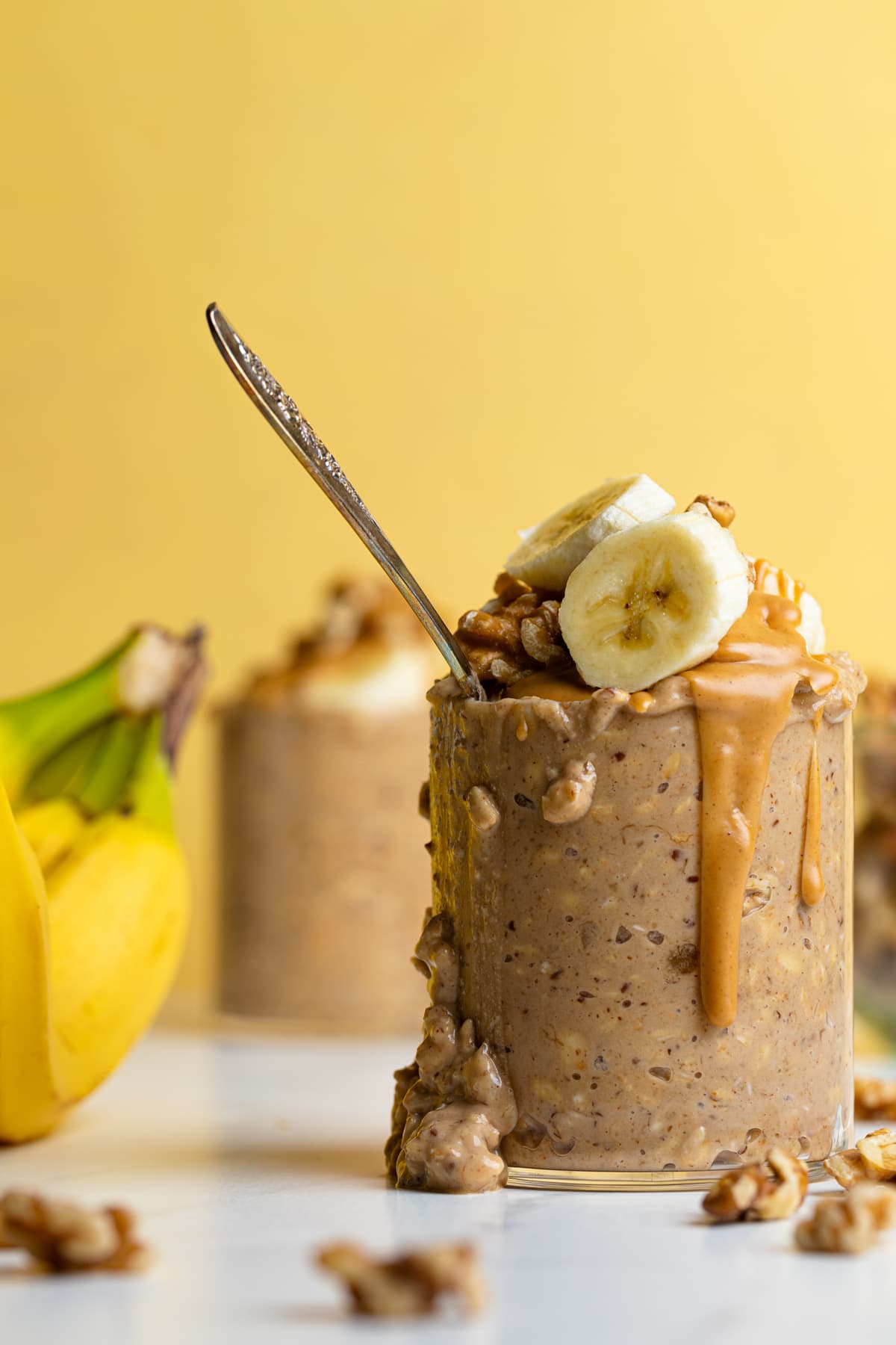 Spoon in a glass of Banana Peanut Butter Overnight Oats.