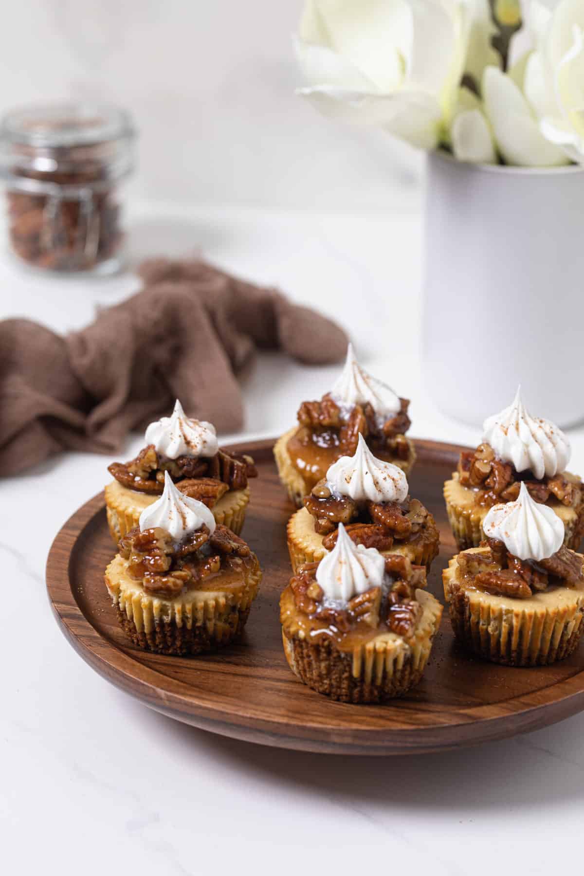 Pecan Pie Cheesecake Bites on a wooden platter.