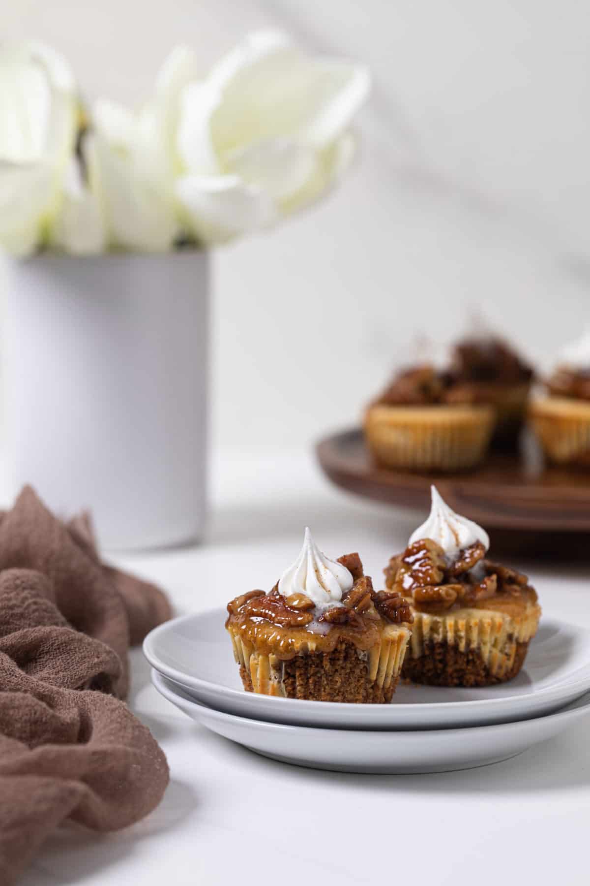 Two Pecan Pie Cheesecake Bites on a small plate.