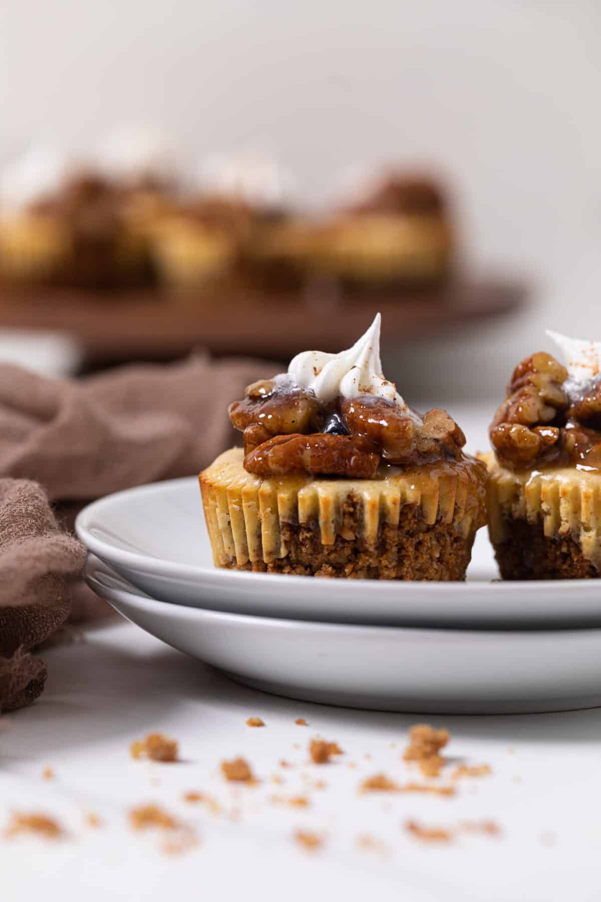 Two Pecan Pie Cheesecake Bites on two small, stacked plates.