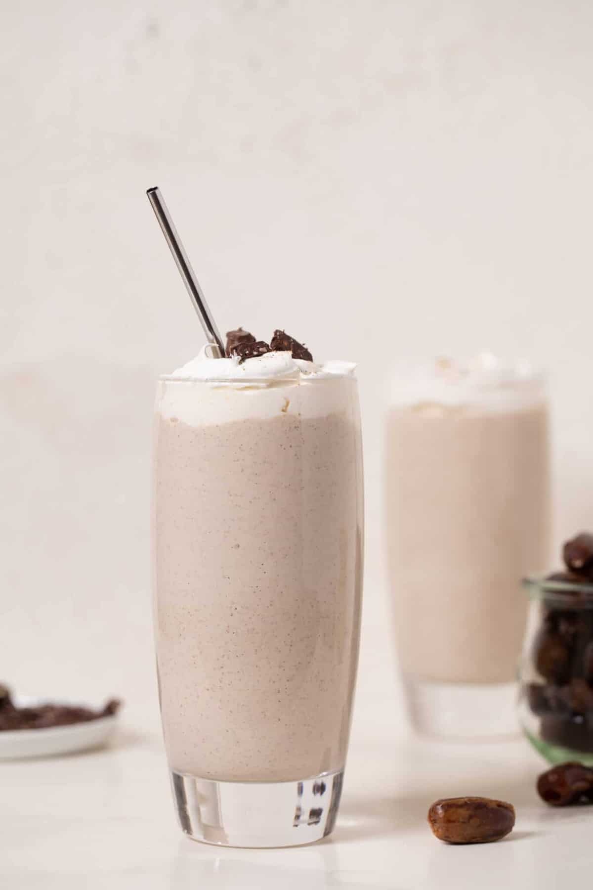 Metal straw in a tall glass of Cashew Date Morning Shake.