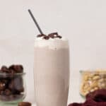 Straw in a tall glass of Cashew Date Morning Shake.