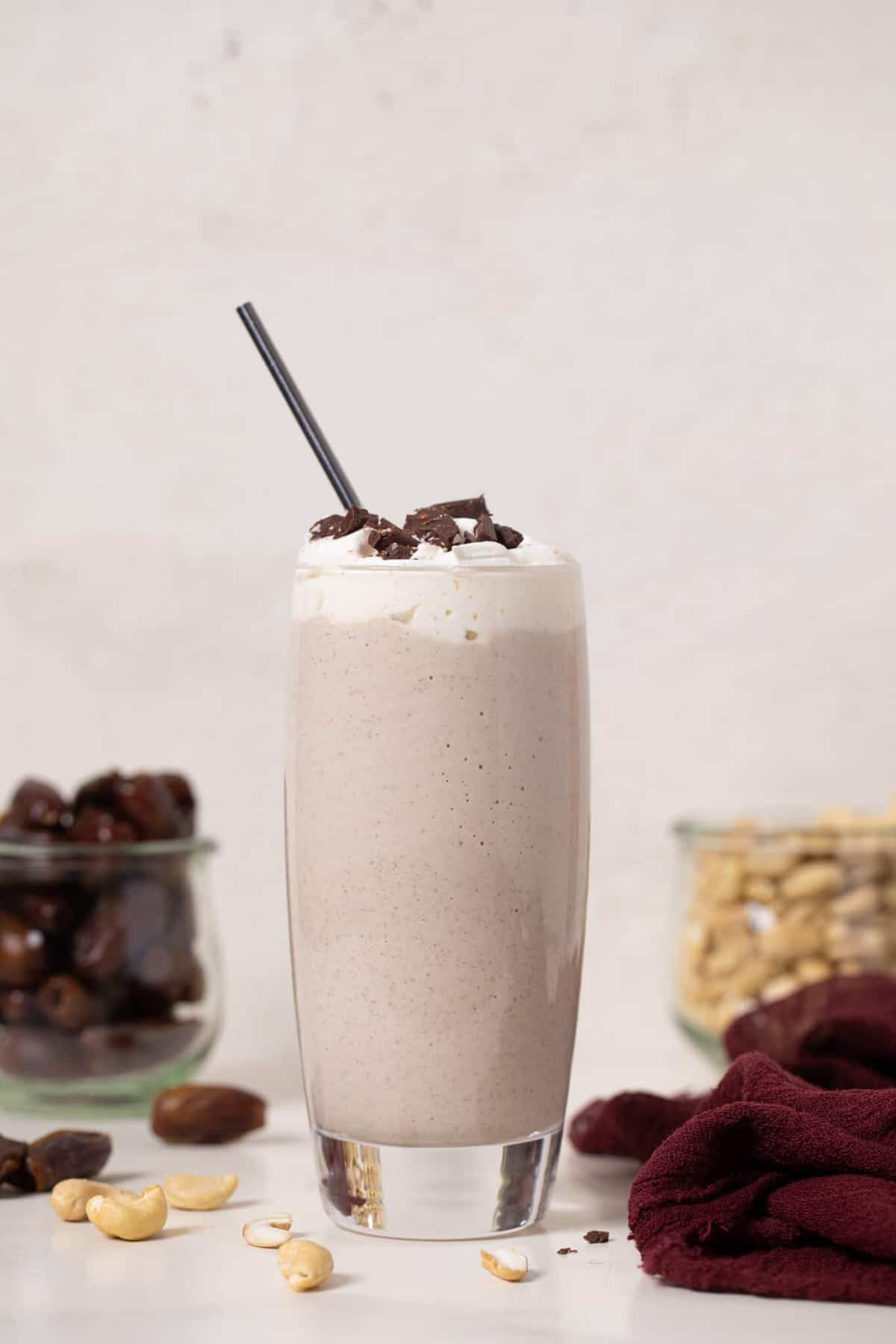 Straw in a tall glass of Cashew Date Morning Shake.