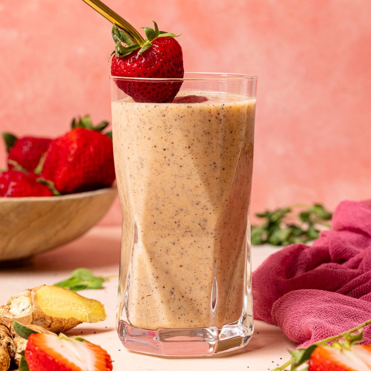 One glass of smoothie with fresh strawberries, ginger, and herbs.