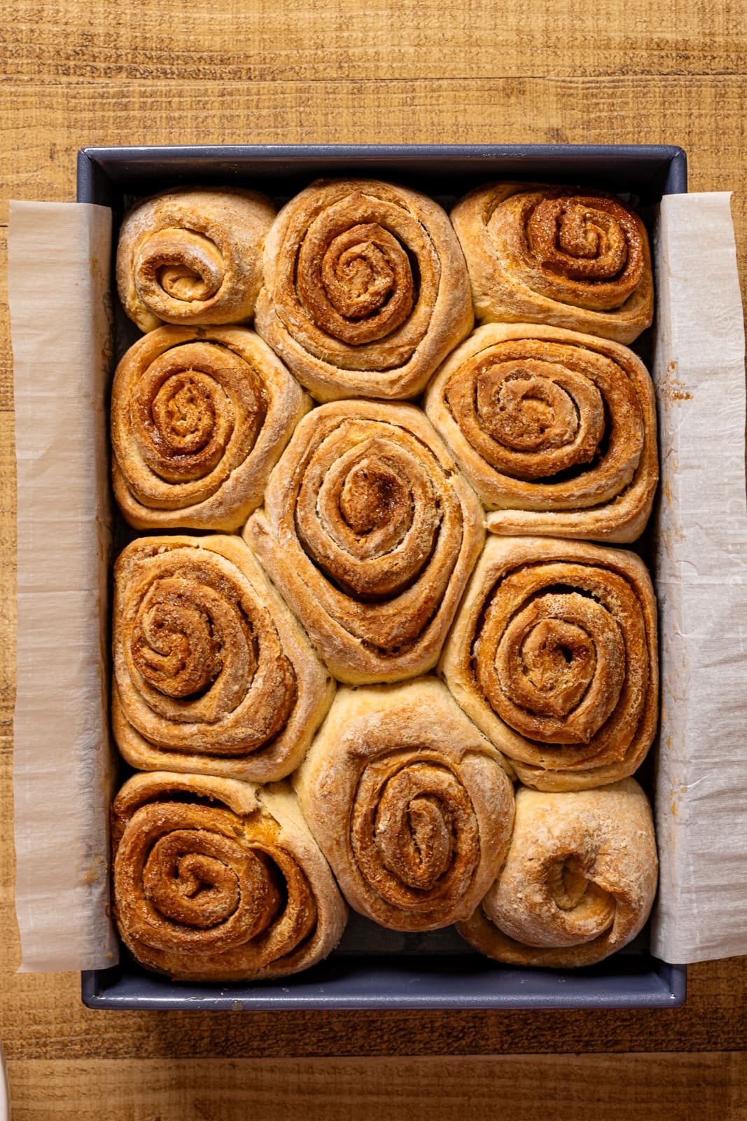 Baked cinnamon rolls in a baking dish.