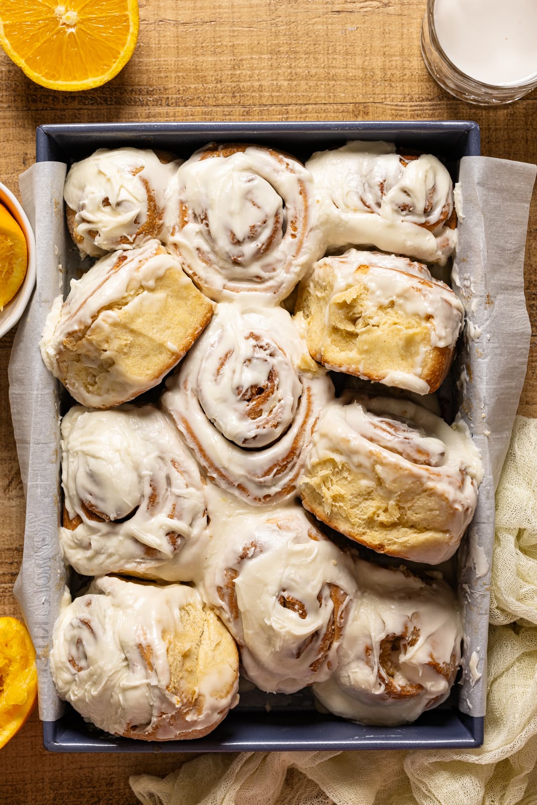 Cinnamon rolls in a baking dish with orange slices.